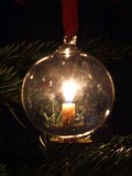 Kerze hinter Weihnachtskugel