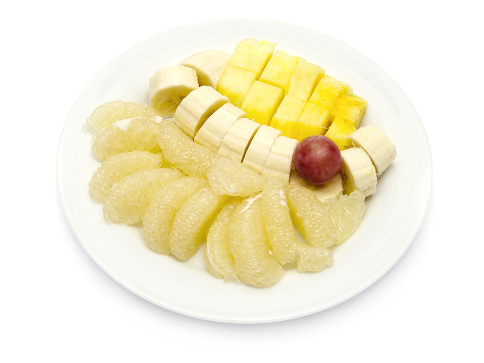 Obstteller mit Ananas, Banane, Sweetie und Weintraube