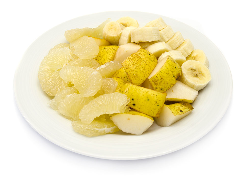 Obstteller mit Ananas, Birne, Banane und Sweetie